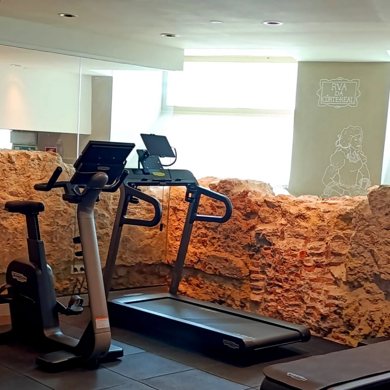 Fitness center with historic stone walls at Corpo Santo Lisbon boutique hotel